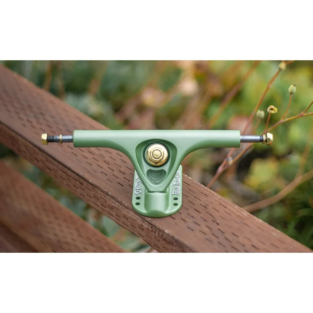 Single Paris V3 180mm 50° longboard truck in Tropic Green with gold hardware, displayed on a wooden rail. - Longboards USA