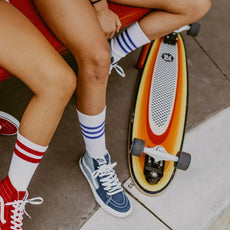Z-Flex Surf-a-gogo Surfskate Log Roll 37-inch longboard with orange and yellow striped deck, white grip pad and gray wheels. - Longboards USA